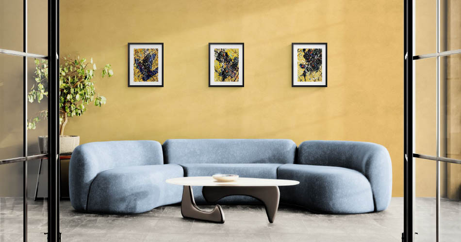 alignement de petits tableaux sur un mur jaune au-dessus d'un canapé bleu
