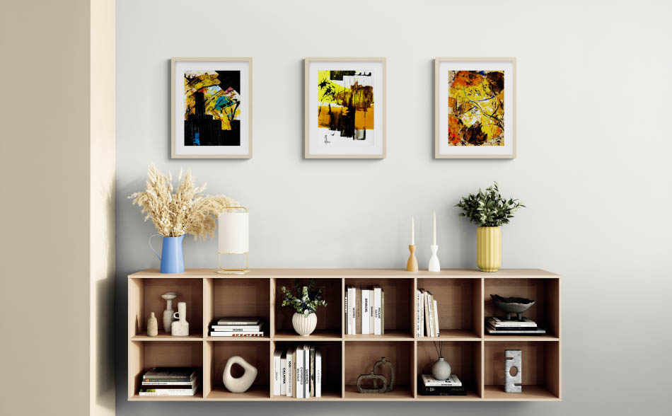 3 petits tableaux colorés au-dessus d'un meuble bas