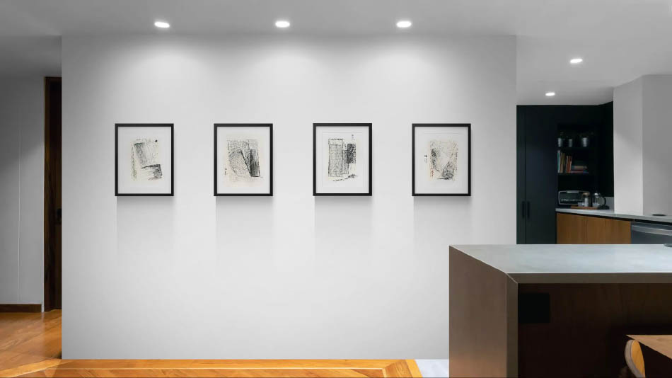 4 petits tableaux alignés sur un grand mur blanc