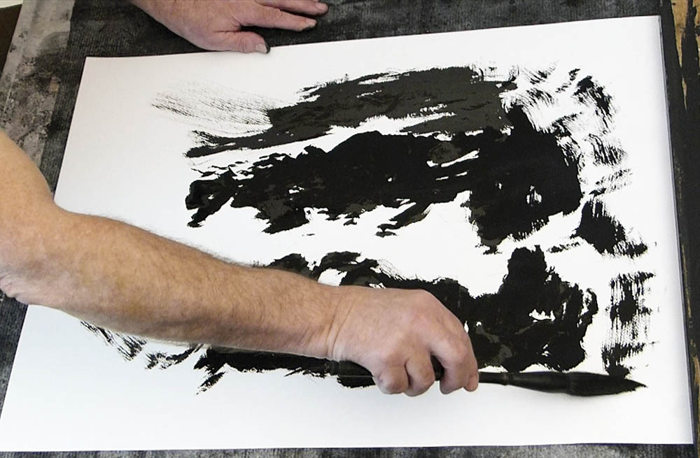 L'artiste abstrait JJ Marie sur une oeuvre à l'encre de Chine